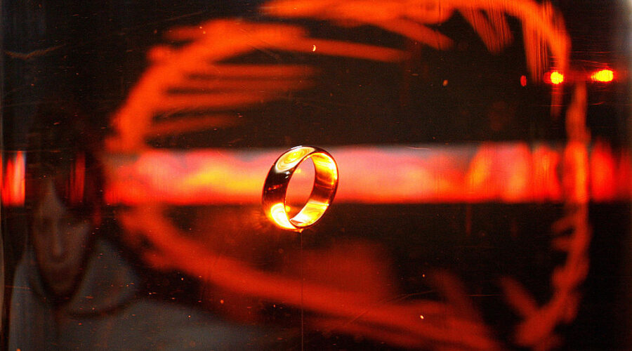Potsdam, GERMANY: A woman looks at the original ring from the film "The Lord of the Rings" 30 January 2007 at an exhibition in Potsdam, eastern Germany. The exhibition "The Lord of the Rings" at the filmpark Babelsberg in Potsdam features scenes of director Peter Jackson's trilogy is open for visitors from 01 February to 29 April 2007. AFP PHOTO DDP/MICHAEL URBAN GERMANY OUT (Photo credit should read MICHAEL URBAN/DDP/AFP via Getty Images)