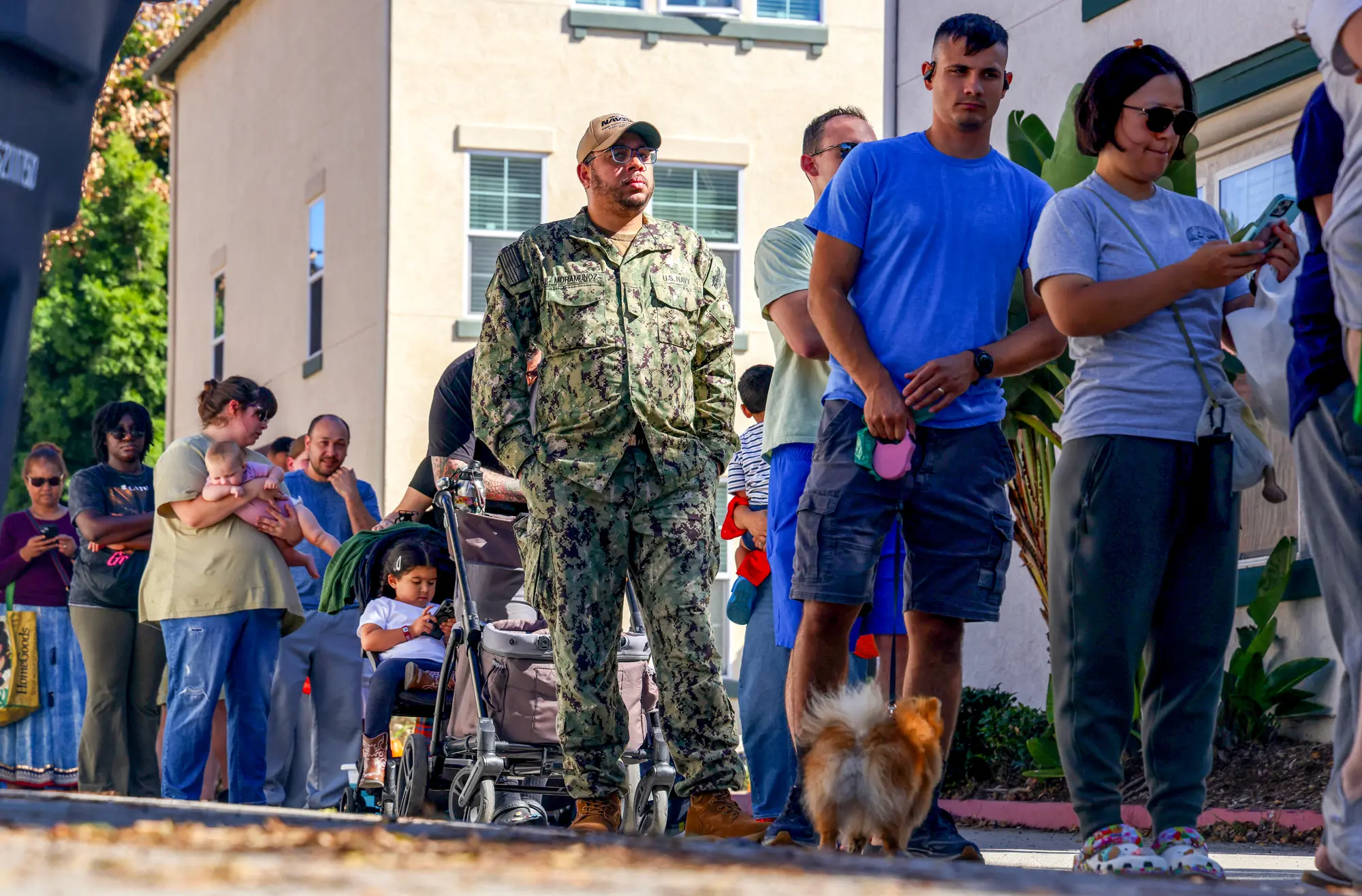 (Příslušník amerického námořnictva čeká ve frontě na bezplatné jídlo, které rozdávají dobrovolníci z potravinové banky Feeding San Diego v San Diegu, 24. října 2025. Sandy Huffaker / AFP / Getty Images)
