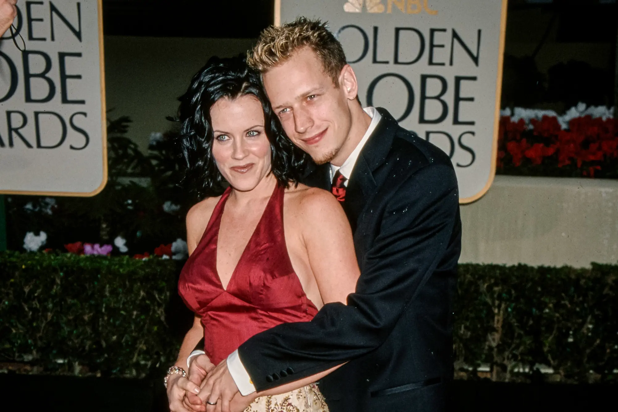 Jenny McCarthyovou objímá její tehdejší manžel, herec John Asher, na 57. ročníku udílení Zlatých glóbů v Beverly Hills v Kalifornii, 23. ledna 2000. McCarthyová, dnes 53letá, se stala celonárodně známou v roce 2005 poté, co zveřejnila příběh o diagnóze autismu u svého syna Evana po očkování MMR. (Vinnie Zuffante / Getty Images)