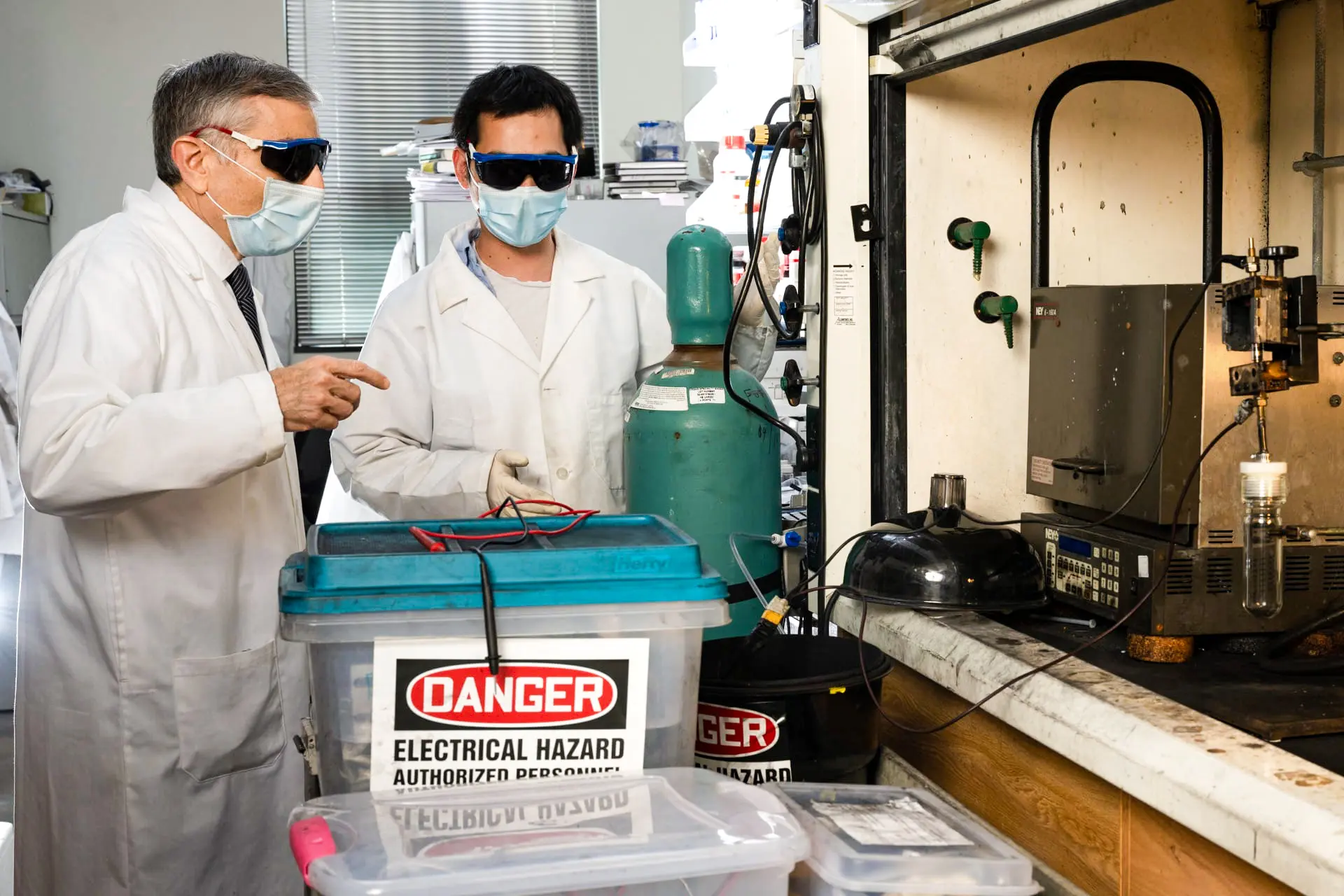 Chemik z Riceovy univerzity James Tour (vlevo) a postdoktorand Bing Deng (vpravo) připravují elektronický odpad k „záblesku“, aby z něj získali cenné kovy k recyklaci. Procesy a postupy v laboratoři, původně vyvinuté k přeměně potravinového odpadu a dalších uhlíkových materiálů na grafen, byly následně upraveny pro získávání dalších surovin. (Jeff Fitlow / Rice University)