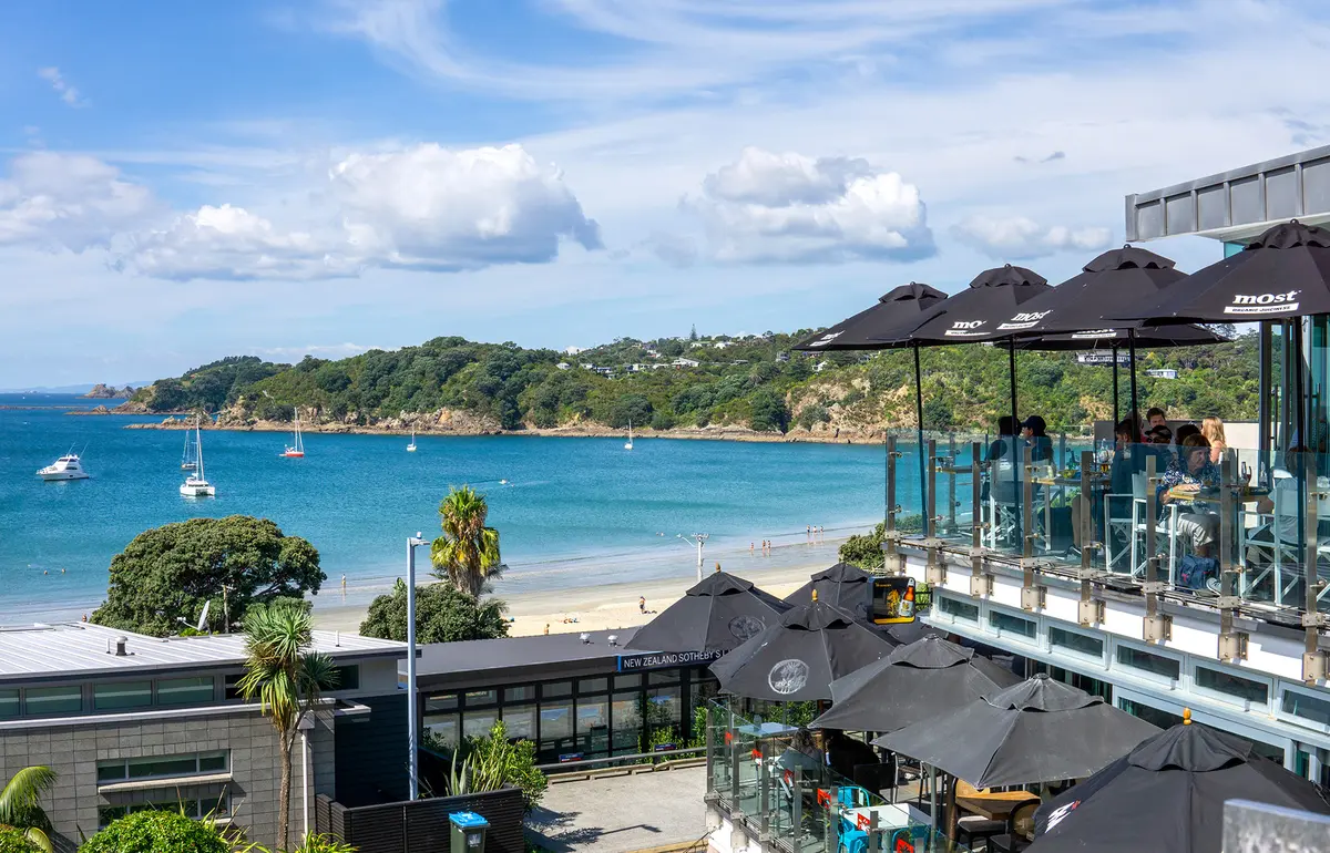 Pláž Oneroa ve vesnici Oneroa na ostrově Waiheke bývá častou první zastávkou návštěvníků přijíždějících z Aucklandu. (cktravels.com / Shutterstock)