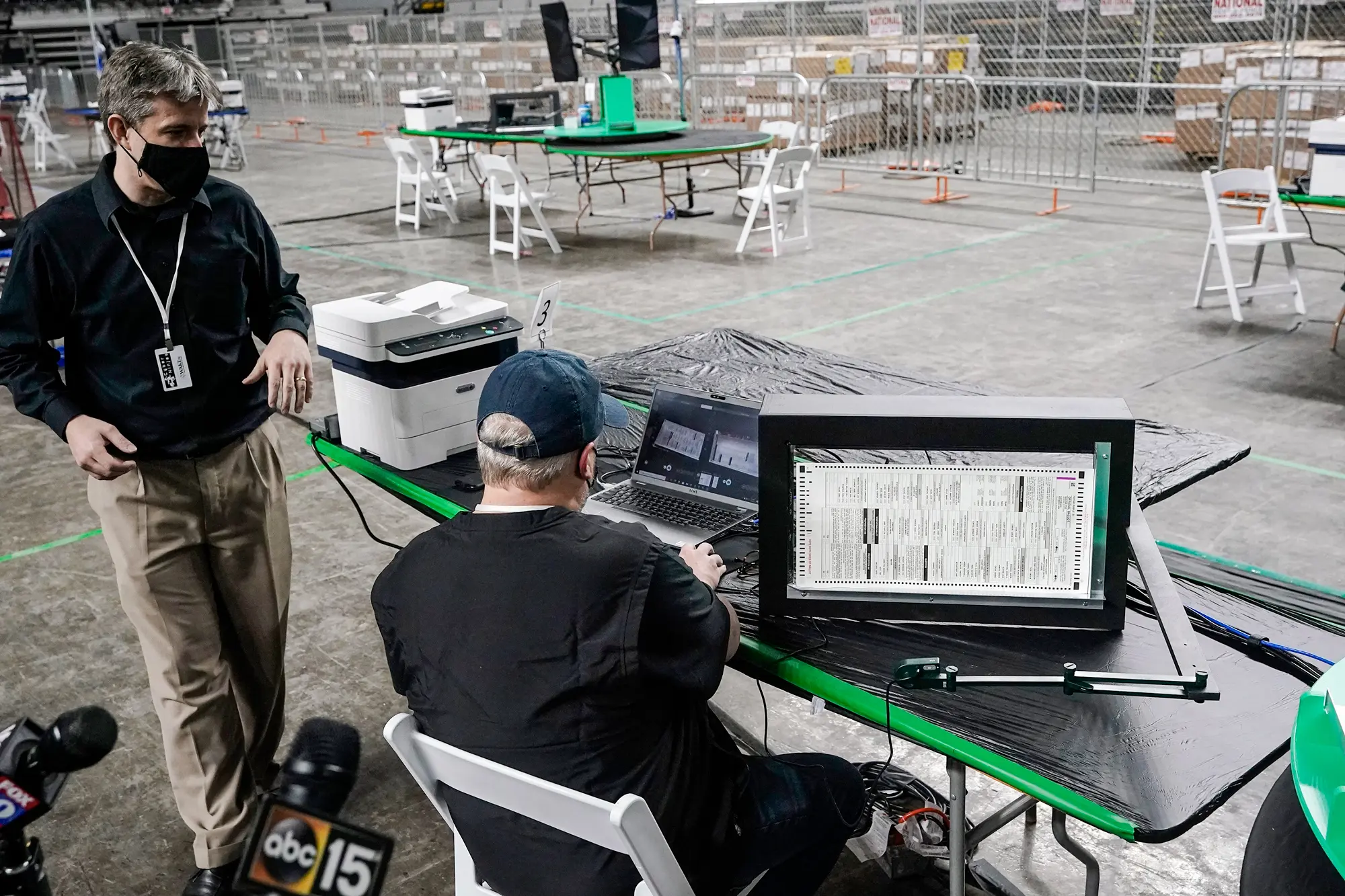 Generální ředitel společnosti Cyber Ninjas Doug Logan (vlevo), jehož floridská poradenská firma dohlížela na audit hlasovacích lístků z voleb v roce 2020 nařízený Senátem státu Arizona, vystupuje v Arizona Veterans Memorial Coliseum ve Phoenixu, 22. dubna 2021. (Ross D. Franklin / AP Photo).