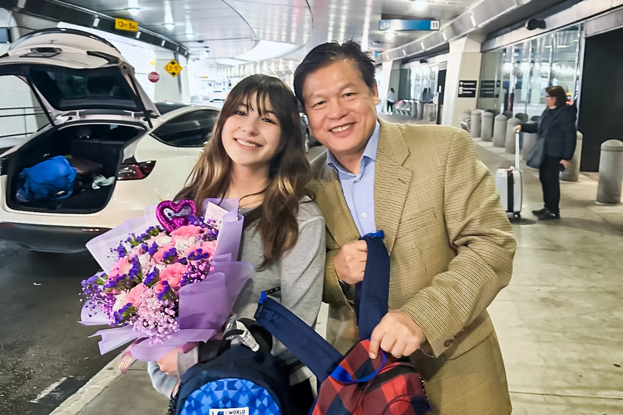 Alysa Liuová a její otec Arthur Liu při jejím návratu z mistrovství světa v krasobruslení 2025 v Bostonu na mezinárodním letišti v San Francisku, v březnu 2025. Alysa na této soutěži získala zlato. (S laskavým svolením Arthura Liu)