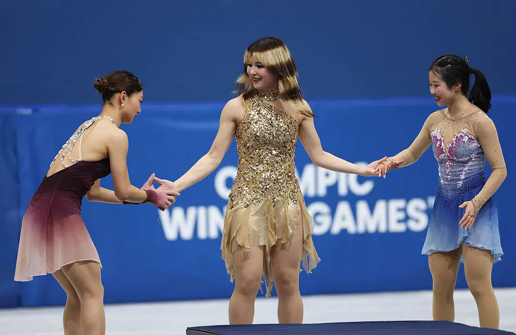 Milán, Itálie – 19. února: Zlatá medailistka Alysa Liuová z týmu USA, stříbrná medailistka Kaori Sakamotová z Japonska a bronzová medailistka Ami Nakaiová z Japonska na stupních vítězů při ceremoniálu individuální ženské soutěže na zimních olympijských hrách Milano Cortina 2026 v Miláně, 19. února 2026. (Elsa / Getty Images)