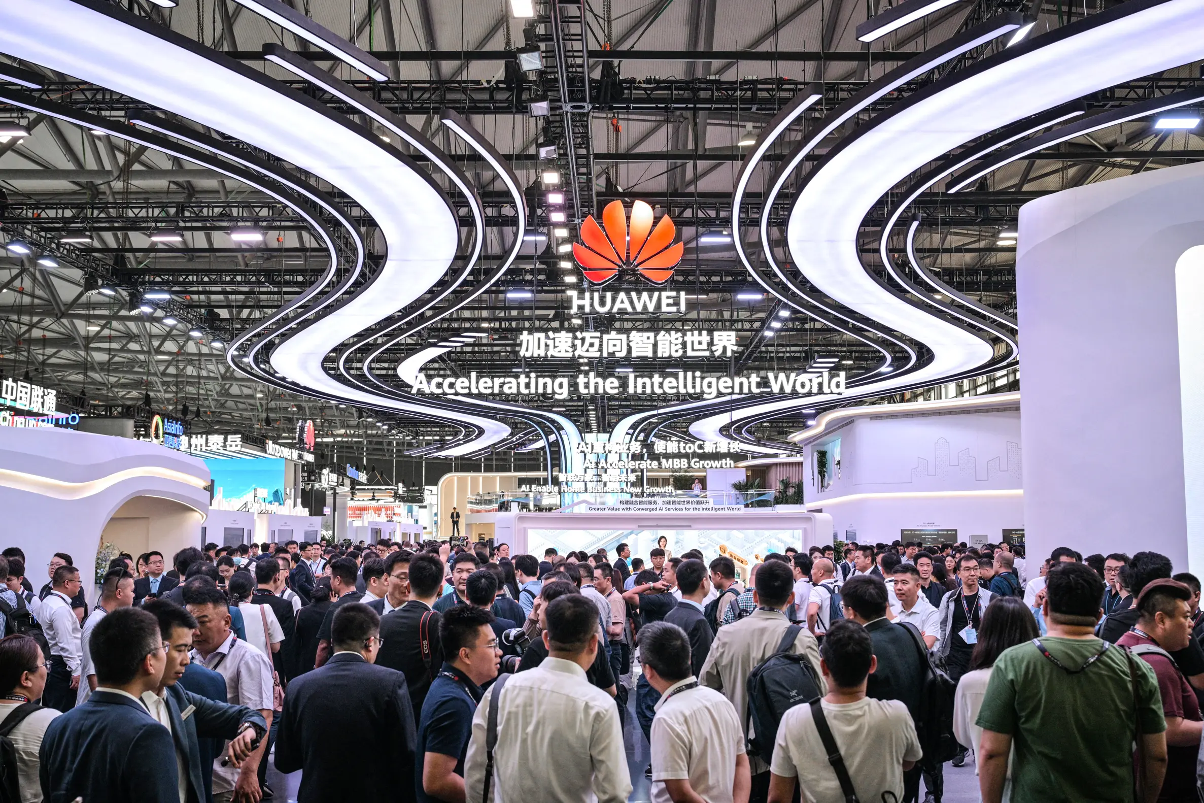 Lidé navštěvují stánek společnosti Huawei během veletrhu Mobile World Congress v Shanghai New International Expo Center v Šanghaji, 18. června 2025. (Hector Retamal / AFP / Getty Images)