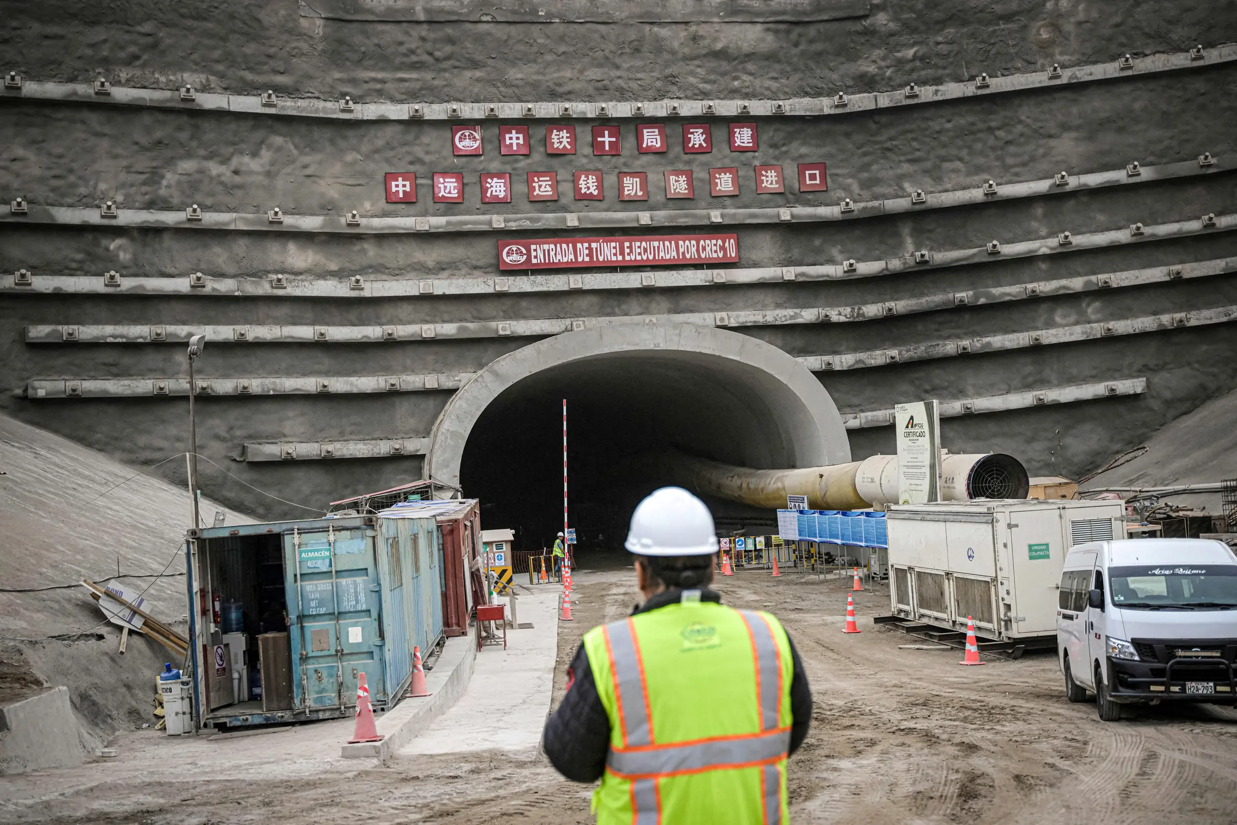 Dělník stojí u vstupu do tunelu na staveništi přístavu v Chancay, který buduje čínská společnost COSCO Shipping, asi 48 mil (77 km) severně od Limy v Peru, 22. srpna 2023. (Ernesto Benavides / AFP / Getty Images)